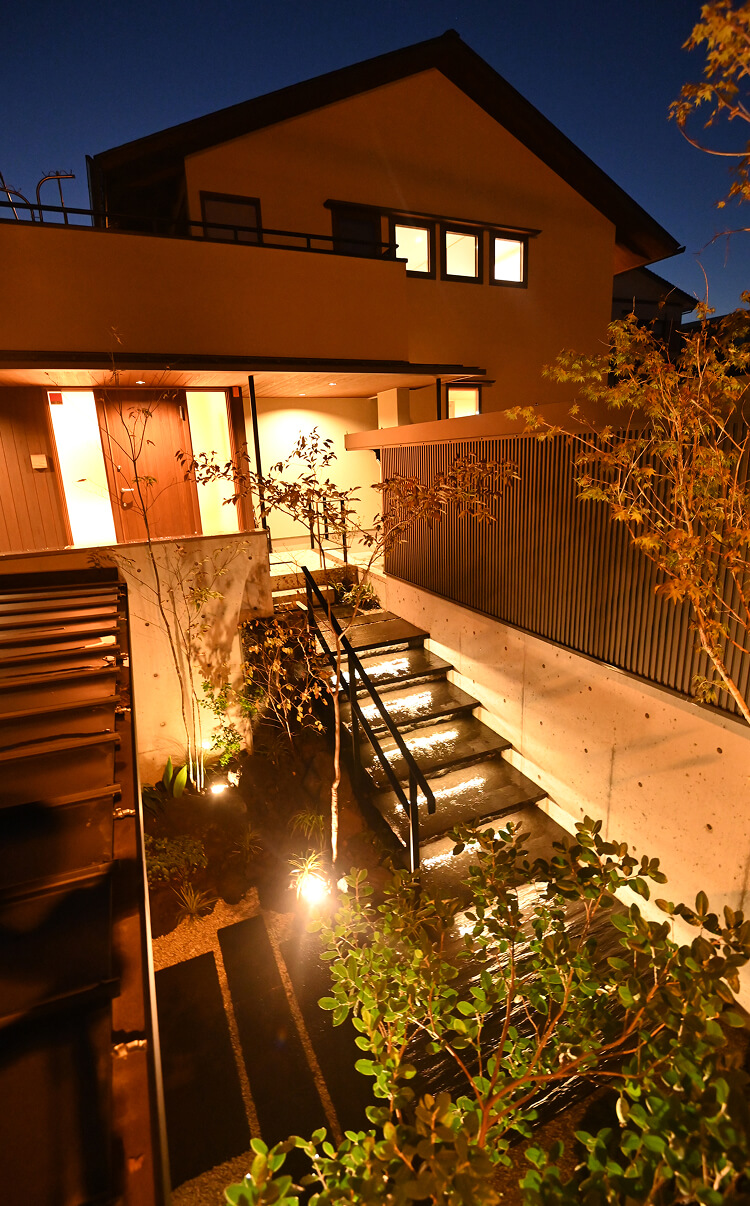階段アプローチを照明で演出したナイトガーデン外構。コンクリート造形と植栽が調和したエクステリアデザイン。